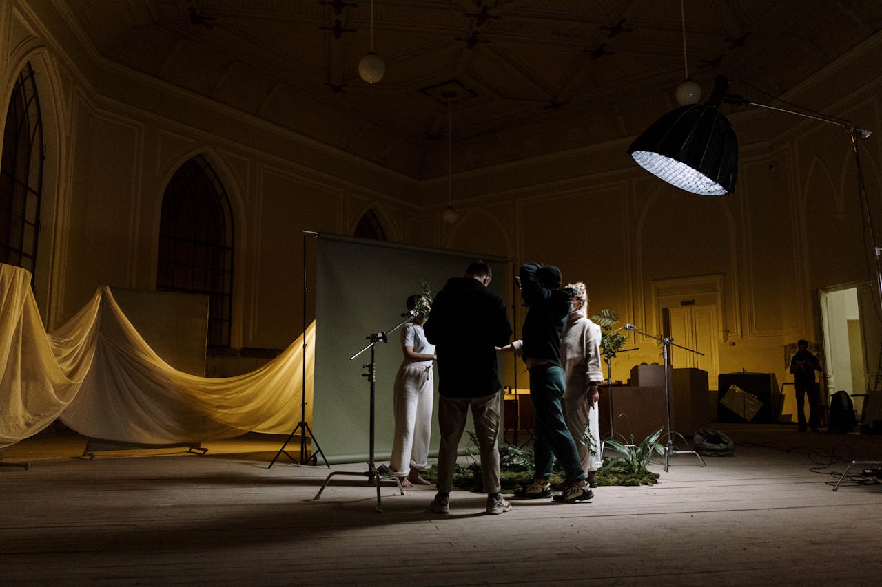 A photography crew setting up lighting and background indoors for a photo shoot.